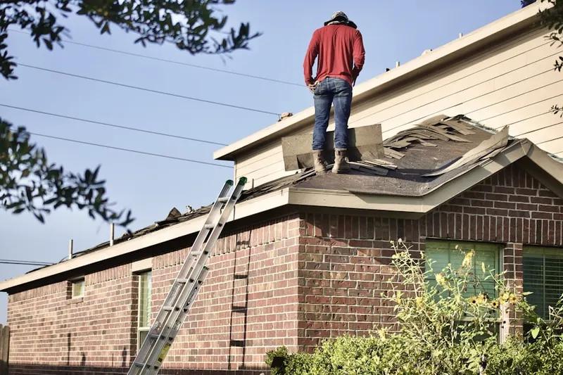 Professional roofer working on a residential roof in Elton